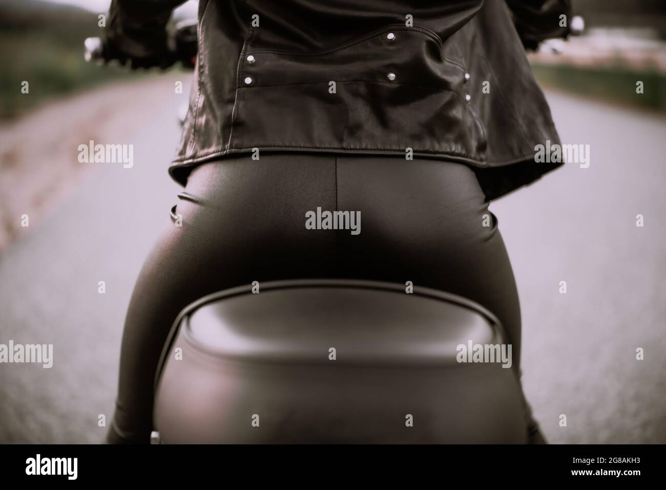 Stilvolle Motorradfahrerin Frau sitzt auf dem Motorrad. Weibliche Treiberin im Freien. Gesäß in Lederhosen. Trip, Cafe Racer, Speed, Freedom-Konzept. Stockfoto