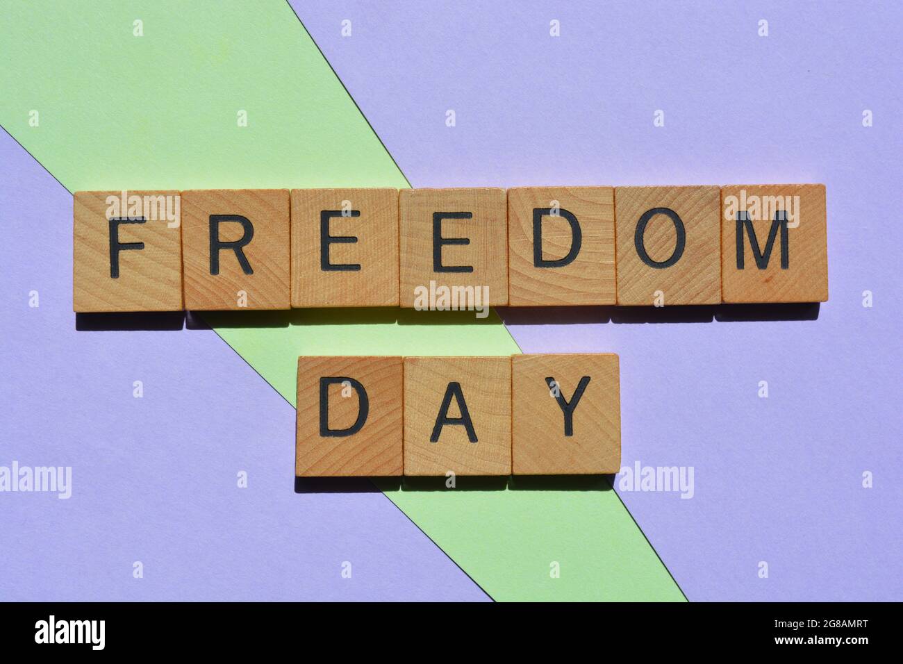 Freedom Day, Wörter in Holz-Alphabet Buchstaben isoliert auf bunten pastellfarbenen Hintergrund Stockfoto