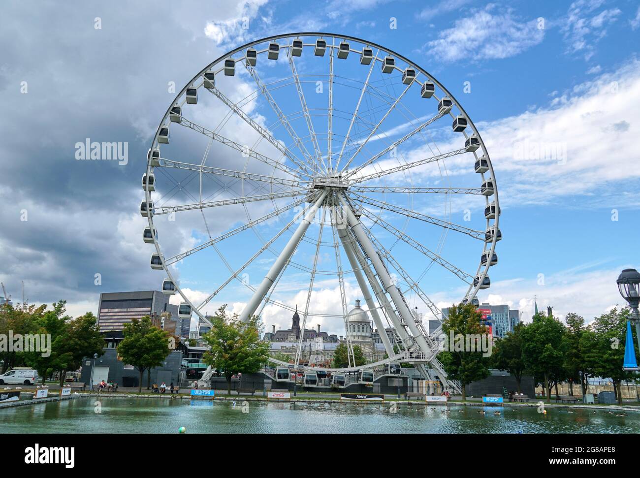 Kanada, Montreal - 11. Juli 2021: Panoramablick auf das Riesenrad La Grande Roue de Montreal im alten Hafen von Montreal über blauen Himmel und Wolken. Das alte P Stockfoto