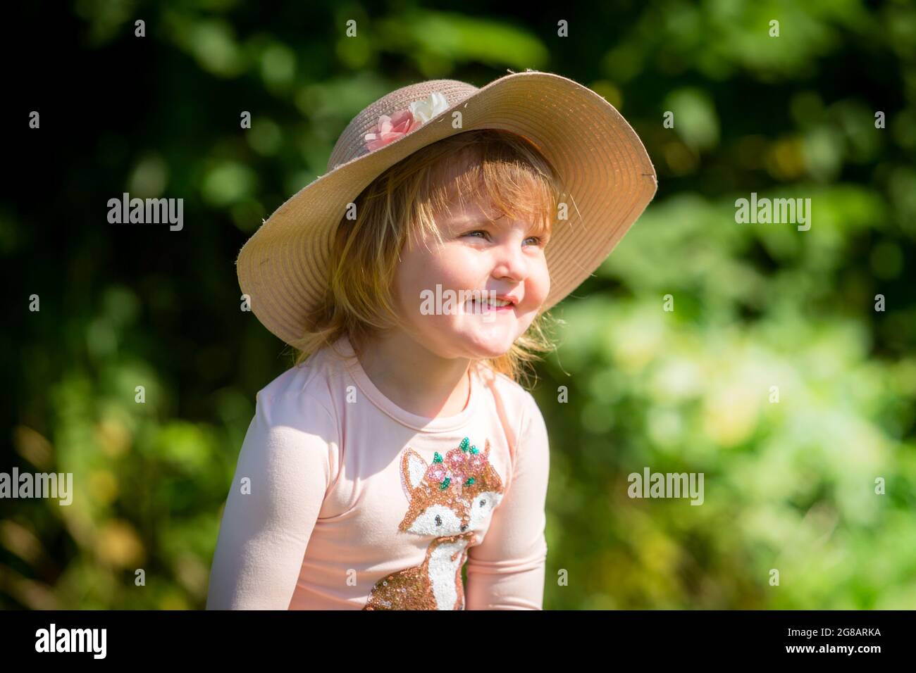Zwei Jahre altes weißes Mädchen in der Nähe trägt einen Hut und lächelt Stockfoto