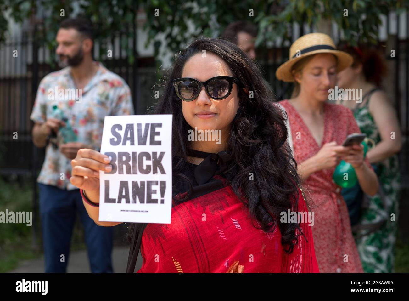 Tasnima Uddin, Gründerin von NijjorManush, die Bengalis und Bangladeshis aus Großbritannien vertritt, hält während der Demonstration ein Flugblatt mit der Aufschrift Save Brick Lane.The Truman Brewery Complex in London, Die Familie Zeloof ist seit langem ein Ort, an dem verschiedene Kunst- und Kulturveranstaltungen veranstaltet werden, und bietet auch erschwingliche Mietpreise, um kleine lokale Unternehmen zu unterstützen. Vor kurzem haben die Zeloof-Brüder vorgeschlagen, den Komplex in ein 5-stöckiges Einkaufszentrum zu verwandeln, was hitzige Kontroversen unter den Menschen in der Nachbarschaft ausgelöst hat. Zu den beteiligten Organisationen gehört das East End Stockfoto
