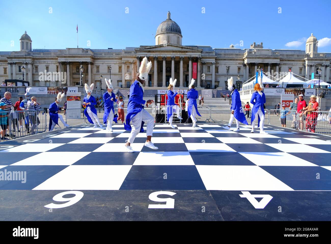 ChessFest, London, Großbritannien. Ein Schachspiel wurde mit 32 Schauspielern in von Alice im Wunderland inspirierten Outfits auf einem riesigen Brett auf dem Trafalgar Square gespielt. Stockfoto