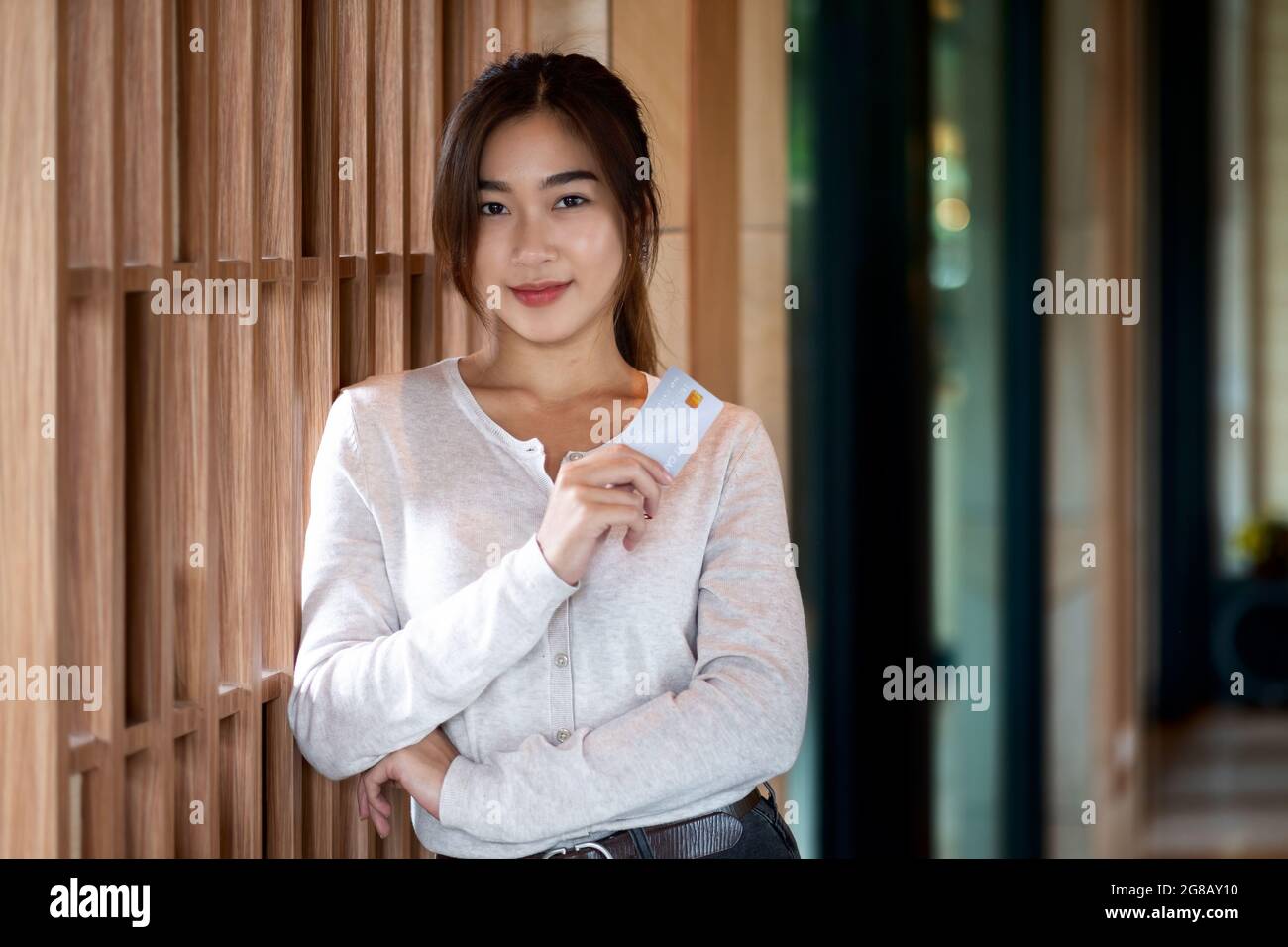 Portrait eines jungen asiatischen Mädchens mit Kreditkarte und Blick auf die Kamera Stockfoto