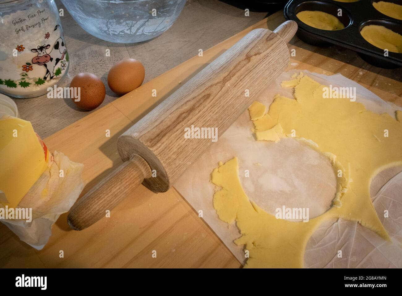 Glutenfreies Gebäck, das auf einem Brett ausgerollt wird und zum Ausschälen von Muffin-Dosen für Savories verwendet wird Stockfoto