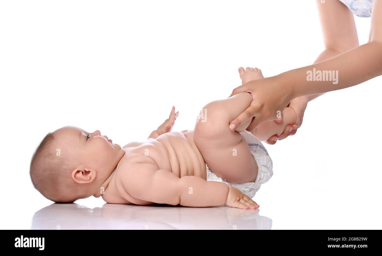 Kleinkind Baby Mädchen Kind in Windel liegt auf ihrem Rücken und macht Übungen, um Beine und Rückenmuskeln zu stärken. Seitenansicht Stockfoto