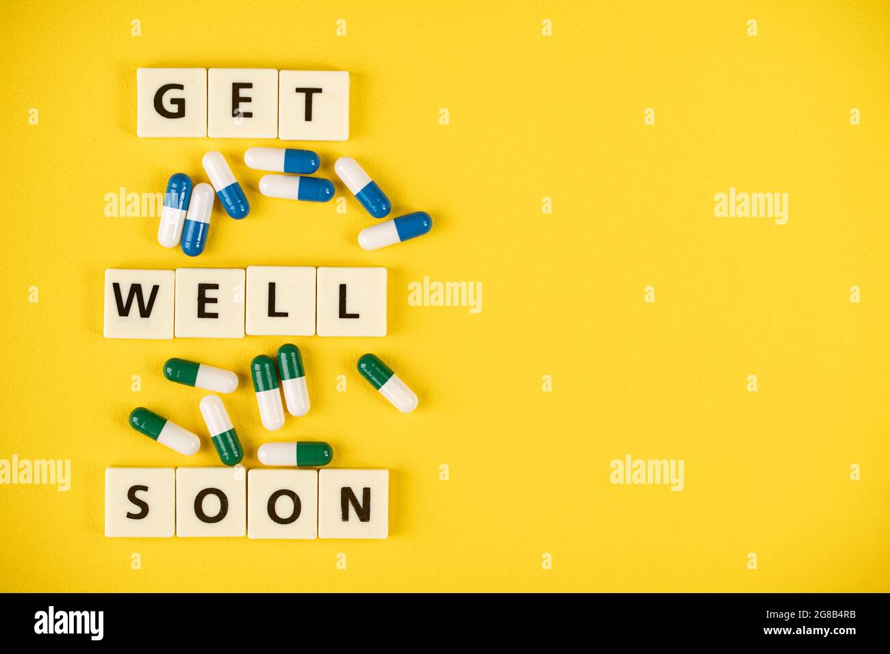 Medizinisches Konzept. Layout von Alphabet-Blöcke und einige Kapsel Pillen mit Text bekommen bald gut. Selektive Fokuspunkte Stockfoto