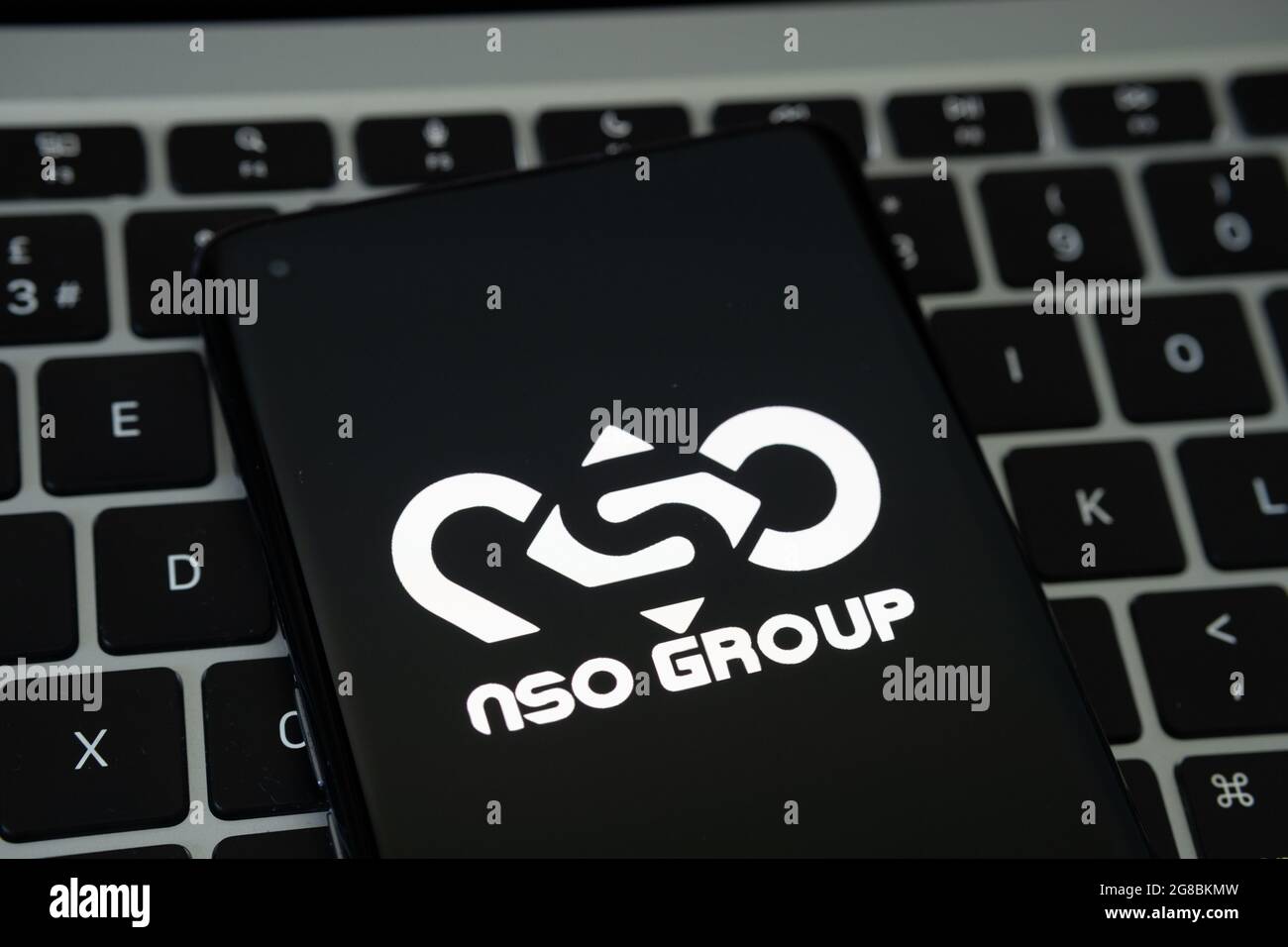 NSO Group Logo auf dem Smartphone auf der Laptop-Tastatur. Israelisches Unternehmen, das für seine Spyware namens Pegasus bekannt ist. Selektiver Fokus. Stafford, Großbritannien Stockfoto