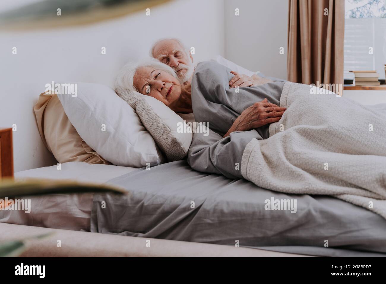 Schönes Seniorenpaar, das zu Hause Zeit zusammen genießt - ältere Menschen, die zu Hause im Bett schlafen Stockfoto