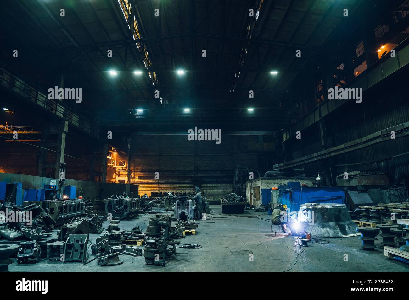 Metallurgische Fabrik Werkstatt Innenraum mit Arbeits Schweißer und Metallprodukte bereit für die Verarbeitung, Schwerindustrie. Stockfoto