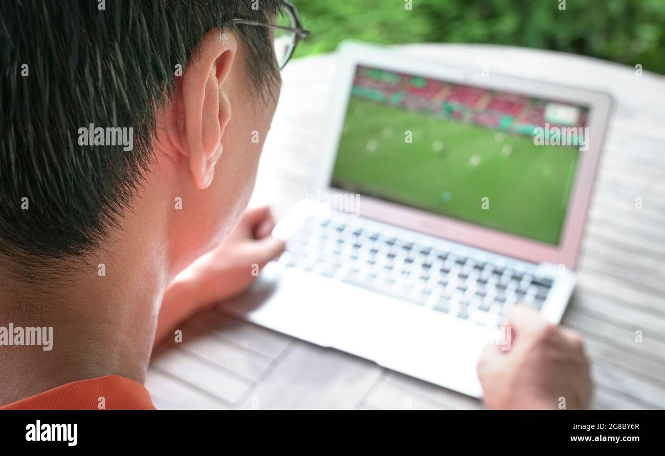 Mann beobachten Fußballsport auf Computer-Laptop. Bleiben Sie zu Hause. Stockfoto