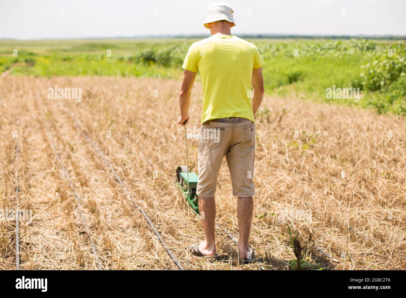 Mann, der auf einem Feld mit manueller Sämaschine ohne Till-Technologie sät. Stockfoto