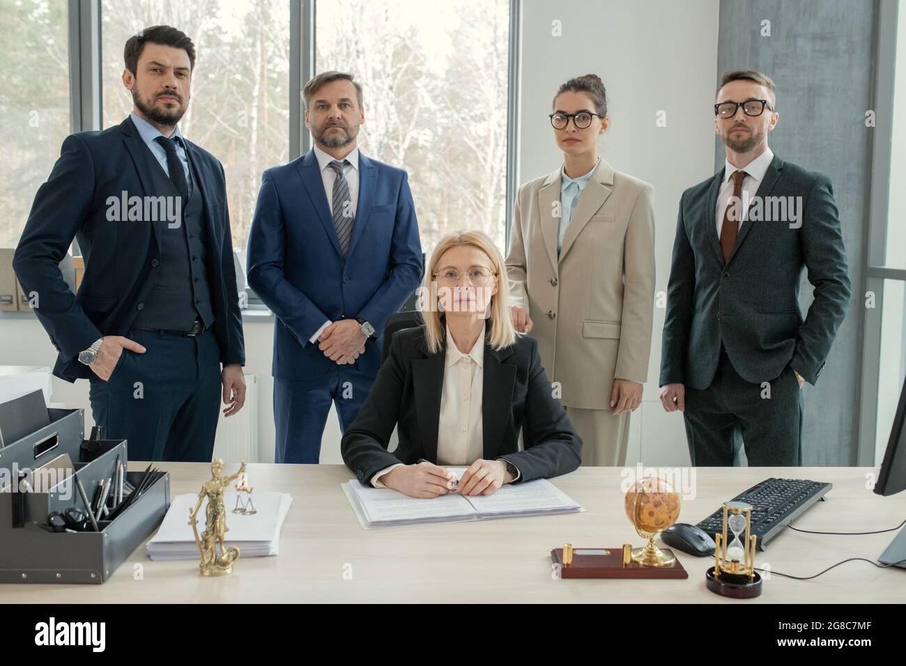 Porträt eines erfolgreichen Geschäftsteams, dessen Führungskraft während der Arbeit im Team im Büro die Kamera anschaut Stockfoto