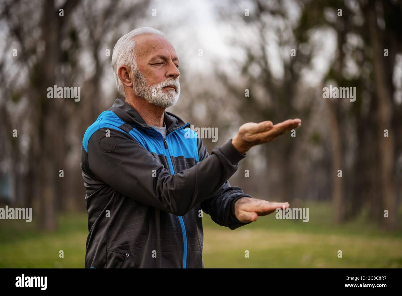 Der ältere Mann praktiziert die Tai-Chi-Übung im Park. Stockfoto