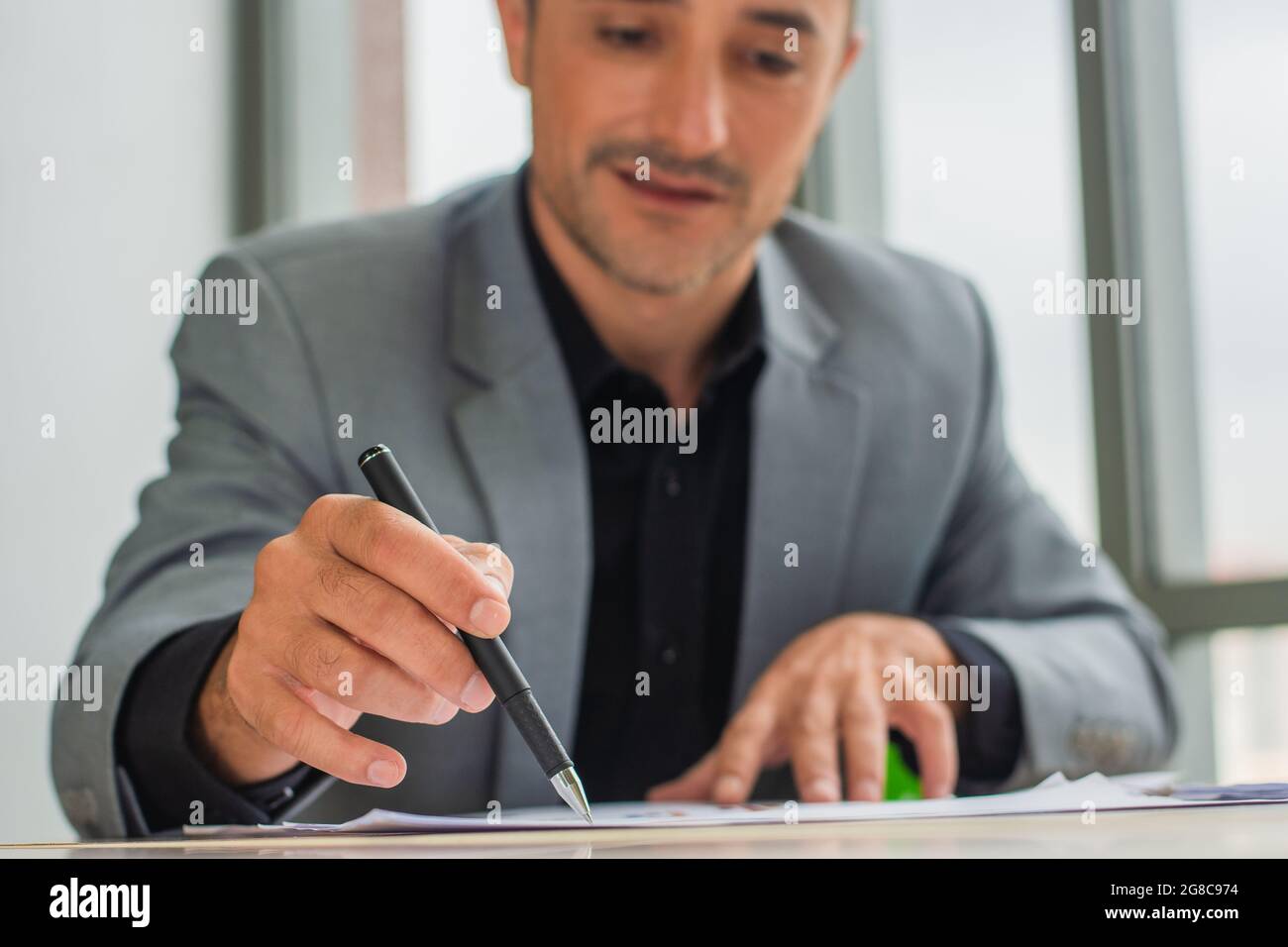 Der Geschäftsmann hält die Unterschrift auf dem Dokument Stockfoto