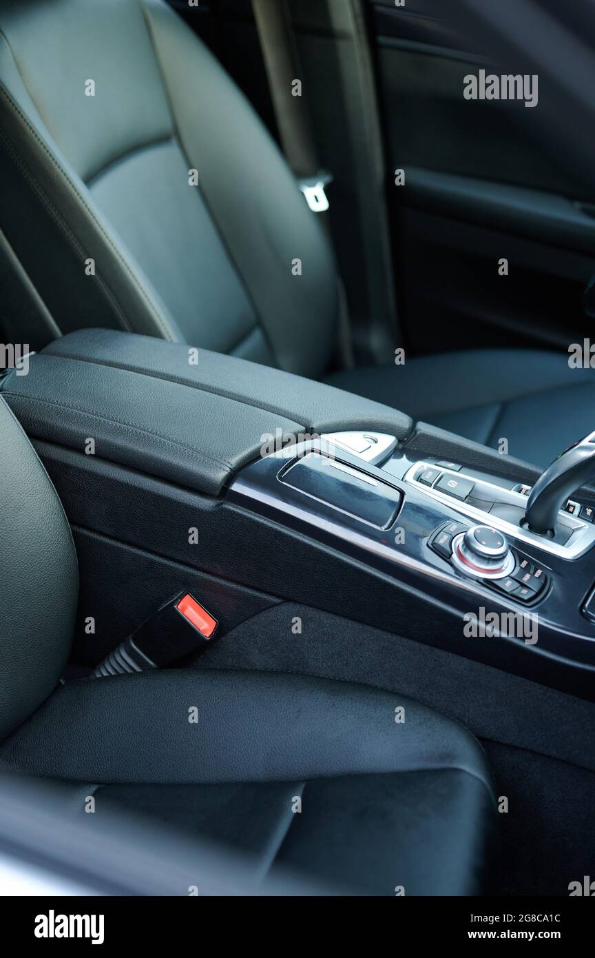 Schwarze Lederarmlehne in der Fahrzeugkonsole mit Gangstab aus der Nähe Stockfoto