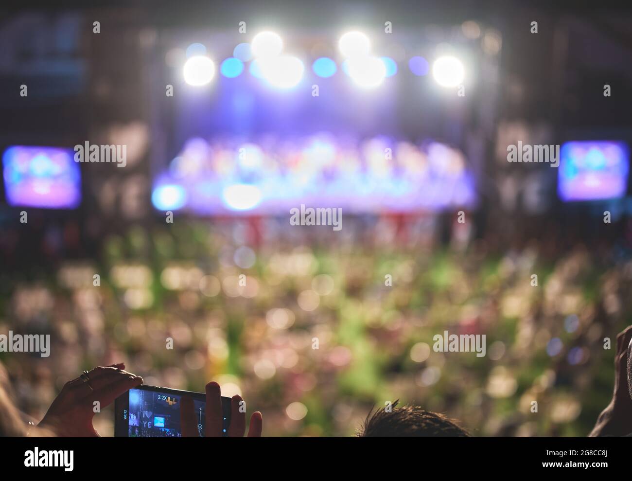 Details von Menschen, die eine nächtliche Show auf ihrem Telefon ansehen und aufzeichnen Stockfoto