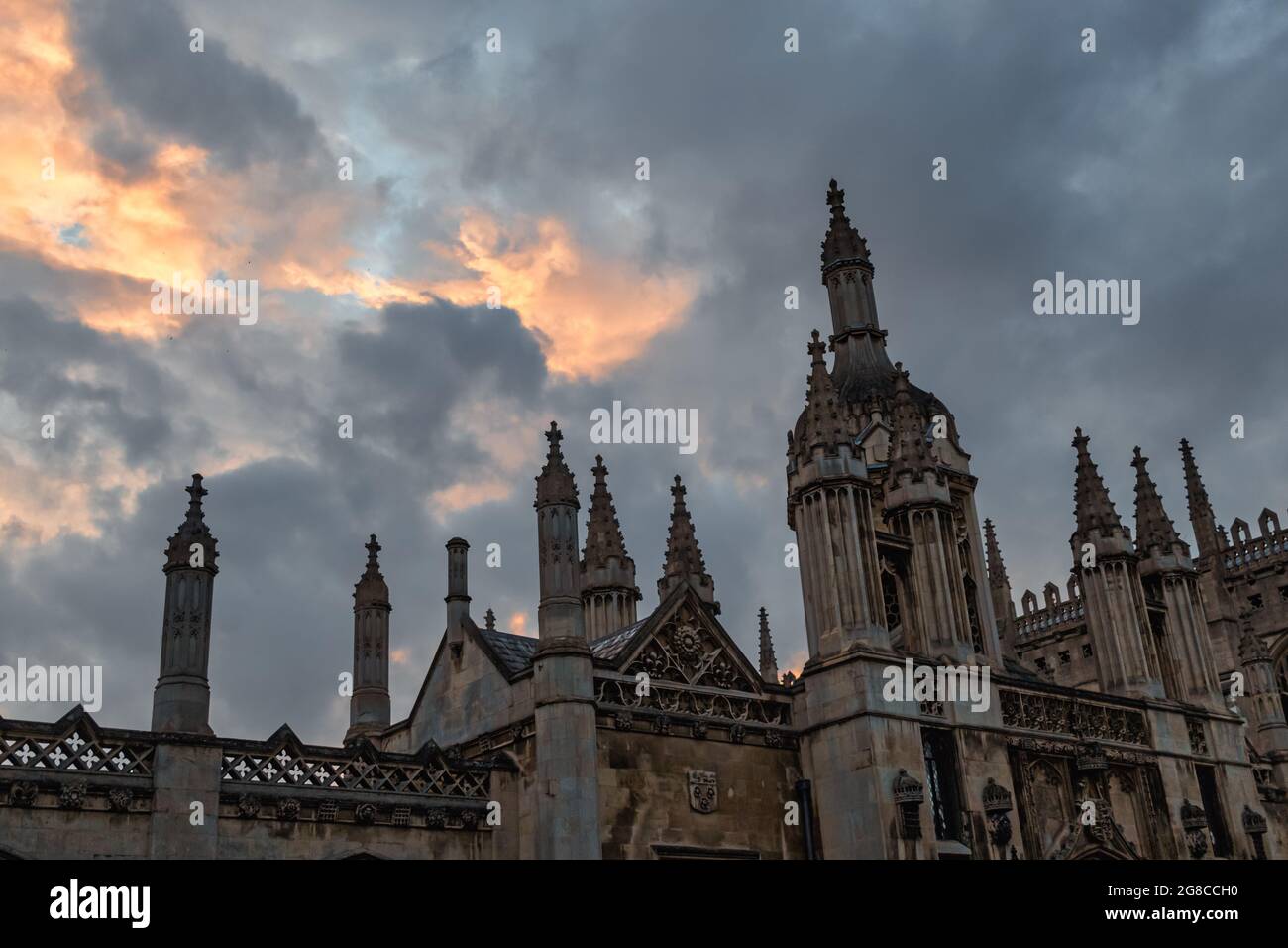 Der obere Bildschirmrand und das Torhaus am Kings College, Cambridge bei Sonnenuntergang mit einem dramatischen Abendhimmel. Stockfoto