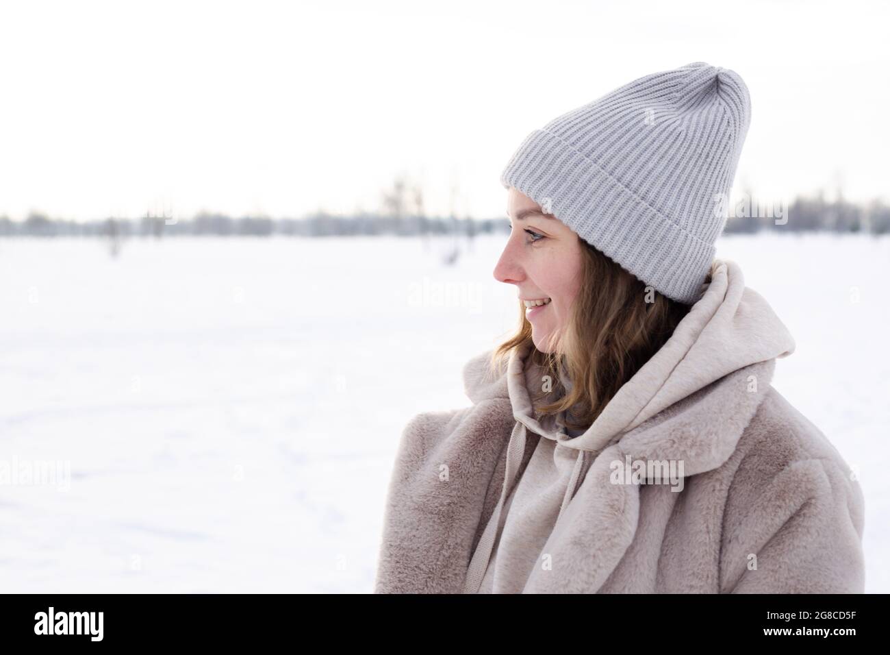 Junges Mädchen in beige Kleidung, Pelzmantel aus Kunstpelz Spaziergänge im Winter Stockfoto