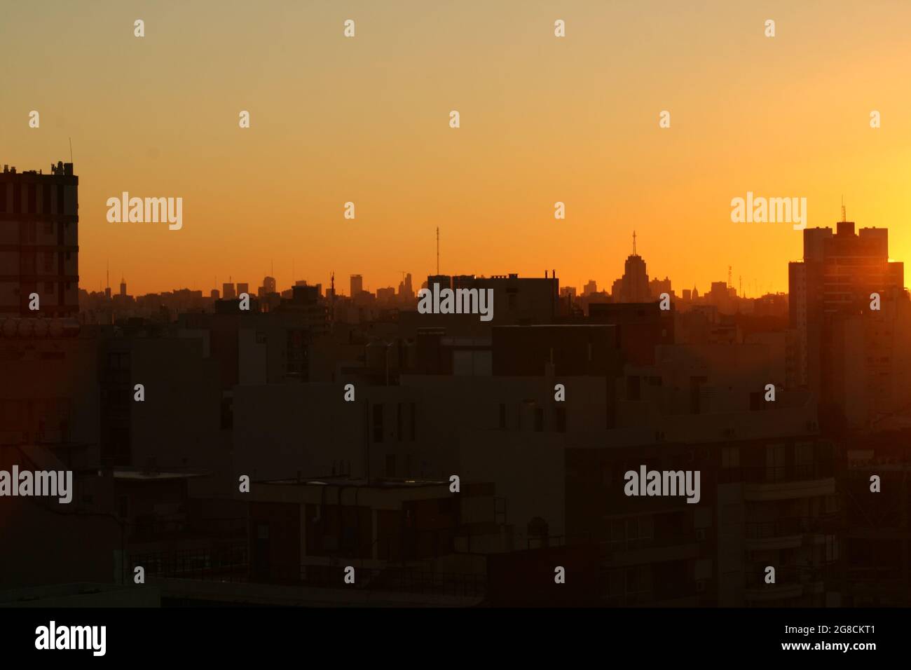 Die Gebäude mit der orangefarbenen Sonne dahinter, Hintergrundbeleuchtung Stockfoto