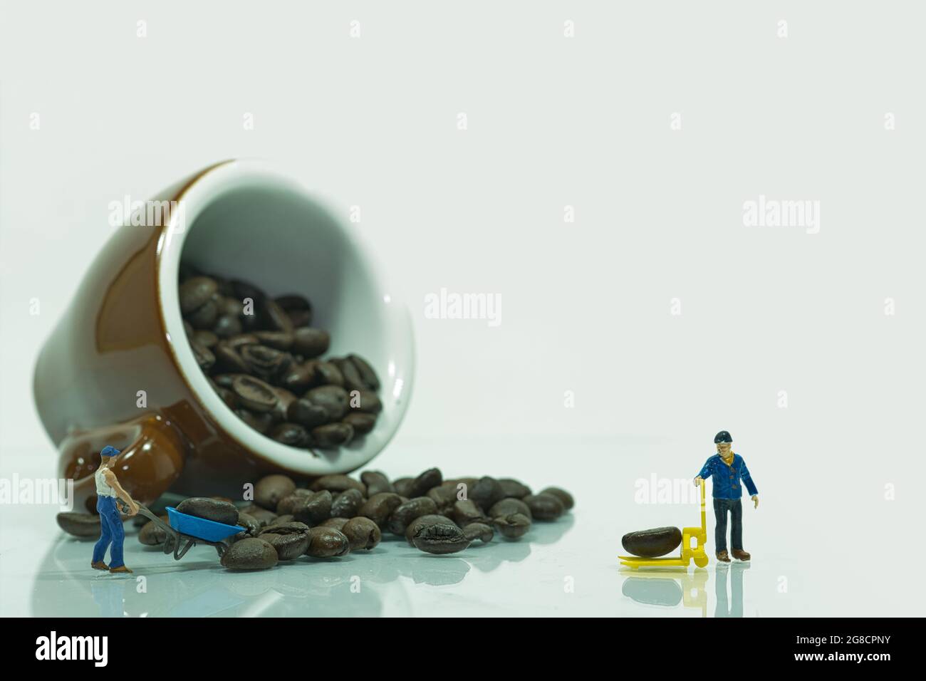 Umgedrehte Espresso Kaffeetasse Gefullt Mit Kaffeebohnen Miniaturarbeiter Transportieren Eine Kaffeebohne Stockfotografie Alamy