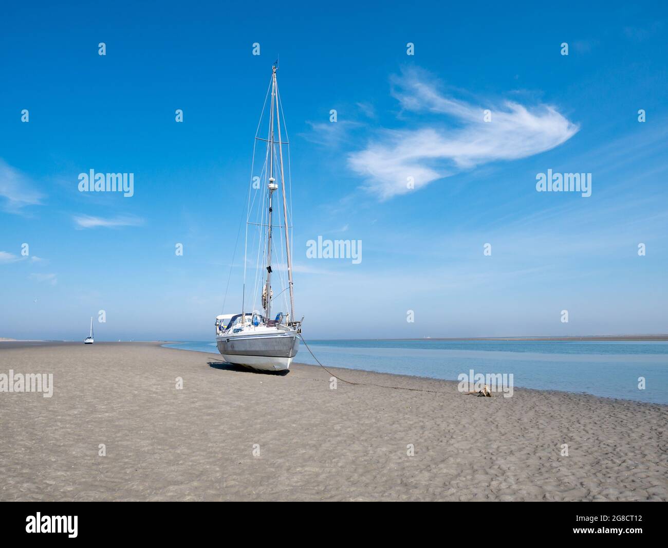 Das Segelboot trocknete bei Ebbe im Wattenmeer auf der Insel Richel in der Nähe von Vlieland, Niederlande, auf flachem Sand aus Stockfoto