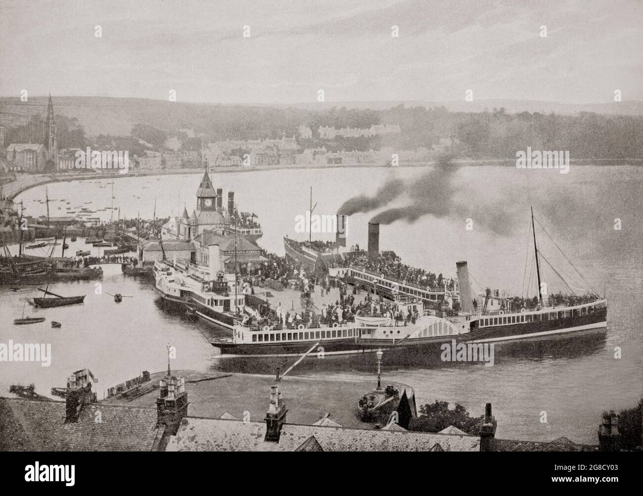 Ein Blick aus dem späten 19. Jahrhundert auf den Hafen in Rothesay, der Hauptstadt auf der Isle of Bute, die an der Küste des Firth of Clyde im council Area von Argyll and Bute, Schottland, liegt. Während der viktorianischen Zeit wurde Rothesay zu einem beliebten Touristenziel. Besonders beliebt war sie bei Glaswegiern, die „den Wassern entgingen“ (wörtlich „das Wasser hinunter“ – eine Referenz an die Gewässer des Firth of Clyde). Der hölzerne Pier war voll mit dem Damastverkehr. Es war die Heimat einer der vielen hydropathischen Einrichtungen Schottlands, die zu dieser Zeit im Trend lagen. Stockfoto