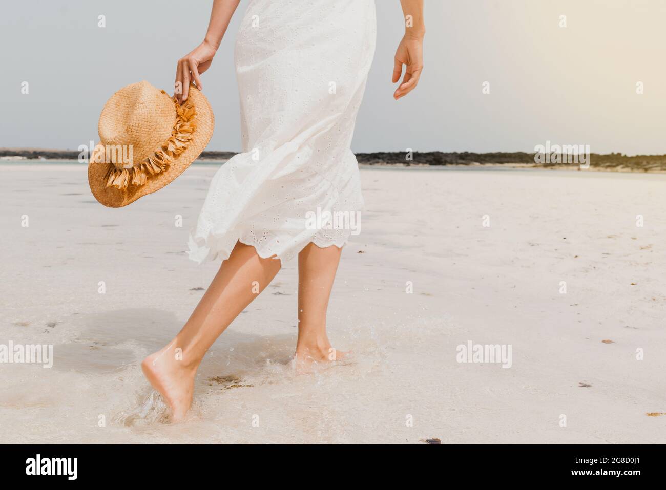 Frau in Kleid zu Fuß am Sandstrand Stockfoto