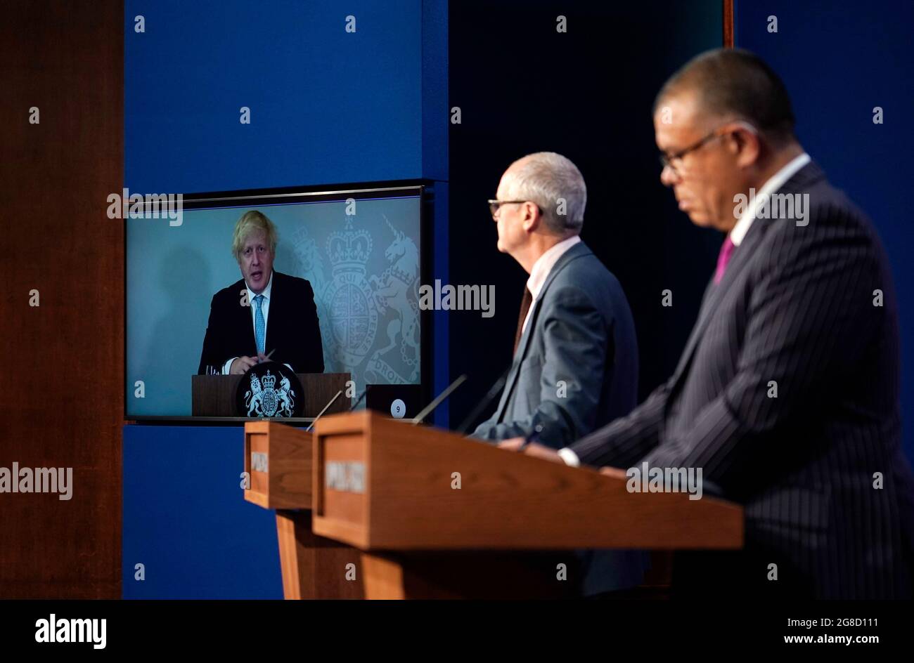 (Von links nach rechts) Premierminister Boris Johnson erscheint auf einem Bildschirm von Chequers, dem Landhaus des amtierenden britischen Premierministers, wo er sich selbst isoliert, der wissenschaftliche Chefberater Sir Patrick Vallance und der stellvertretende leitende medizinische Offizier für England Professor Jonathan Van Tam, während einer Medienbesprechung in der Downing Street, London, über das Coronavirus (Covid-19). Bilddatum: Montag, 19. Juli 2021. Stockfoto