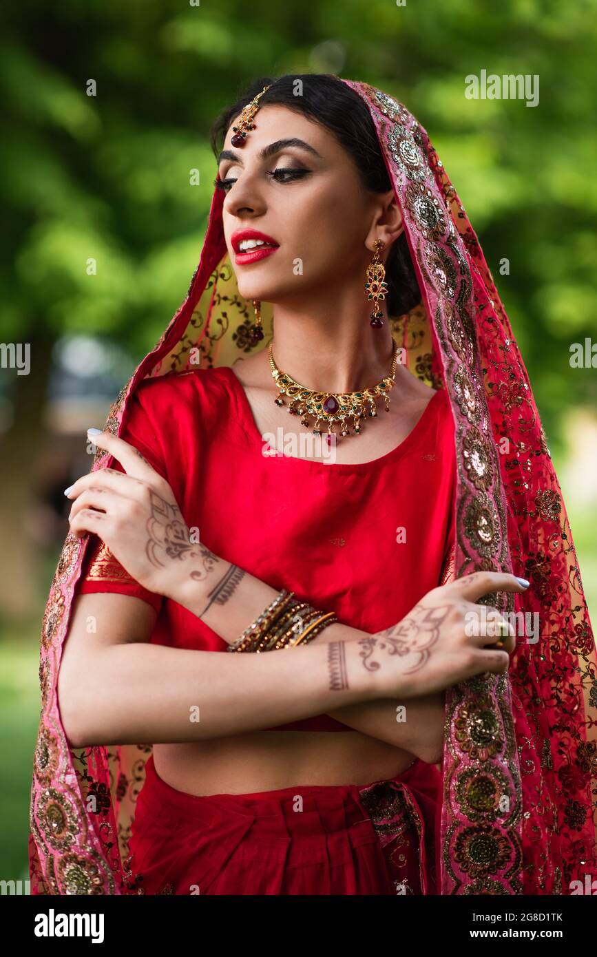 Indische Braut in Sari und Kopftuch in der Nähe verschwommener Mann in  Turban auf dem Hintergrund Stockfotografie - Alamy