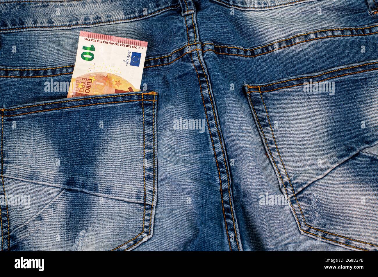 10 Euro, die aus der Tasche der blauen Jeans kommen Stockfoto
