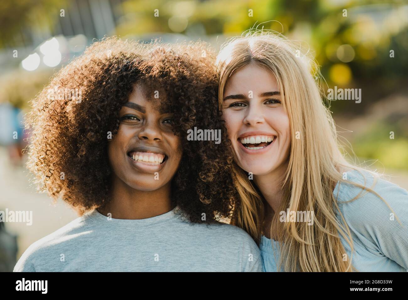 Glückliche, vielfältige Freundinnen, die die Kamera betrachten Stockfoto