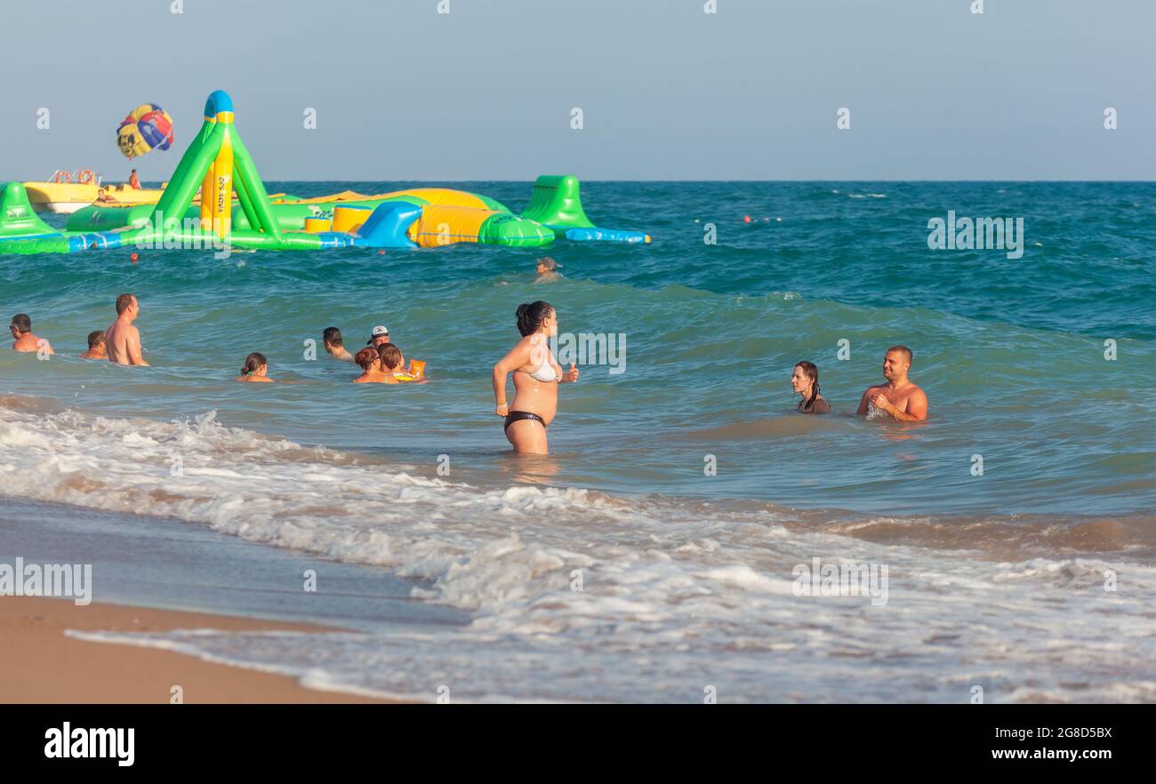 Antalya, Türkei-26. August 2013: Gruppe von fröhlichen Menschen, die sich vor Sonnenuntergang im Sommer in Antalya amüsieren oder im welligen Meer schwimmen. Stockfoto