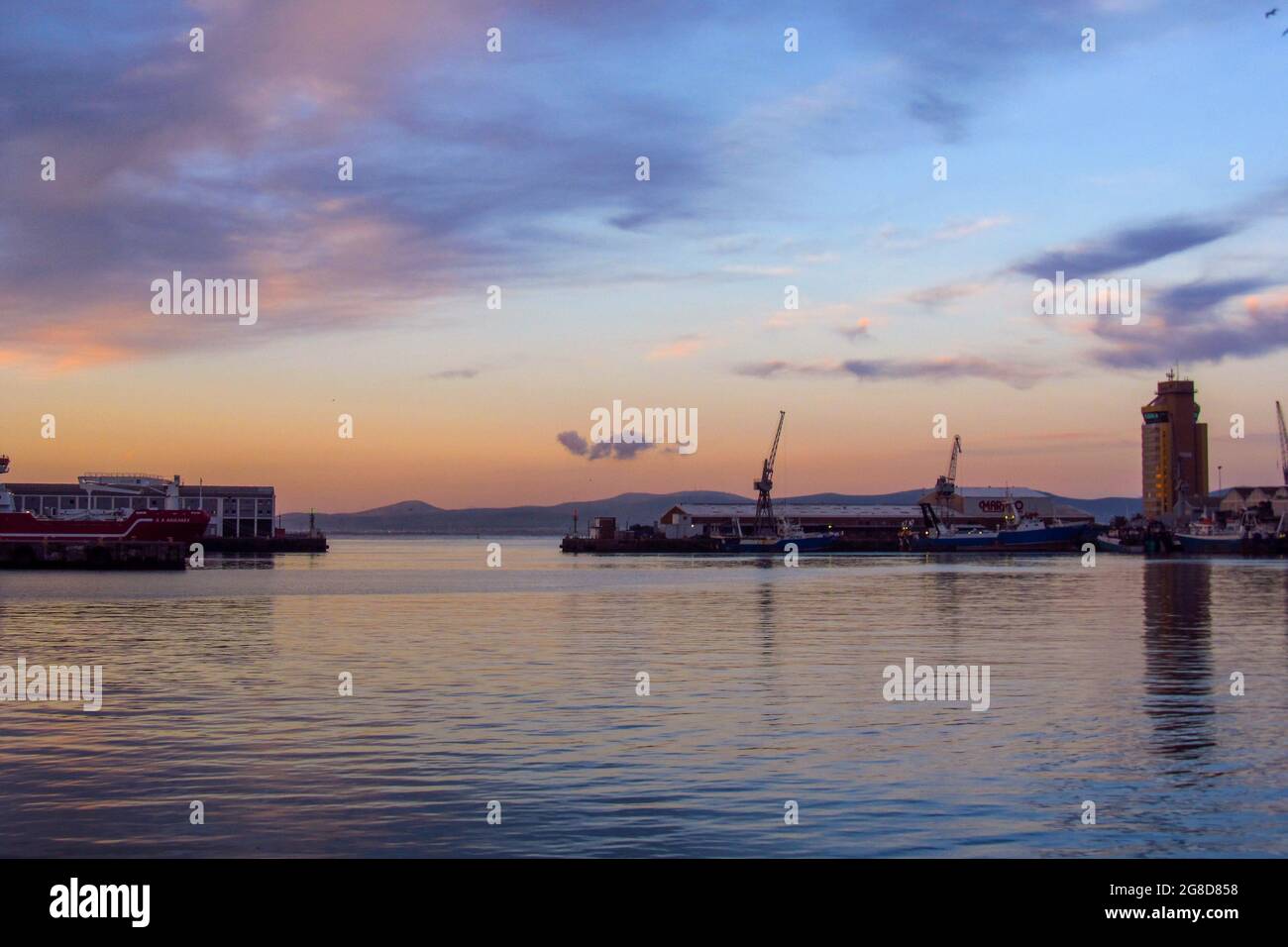 Blick in der Abenddämmerung über die V&A-Uferpromenade, die zum Hafen von Kapstadt in Südafrika gehört. Stockfoto