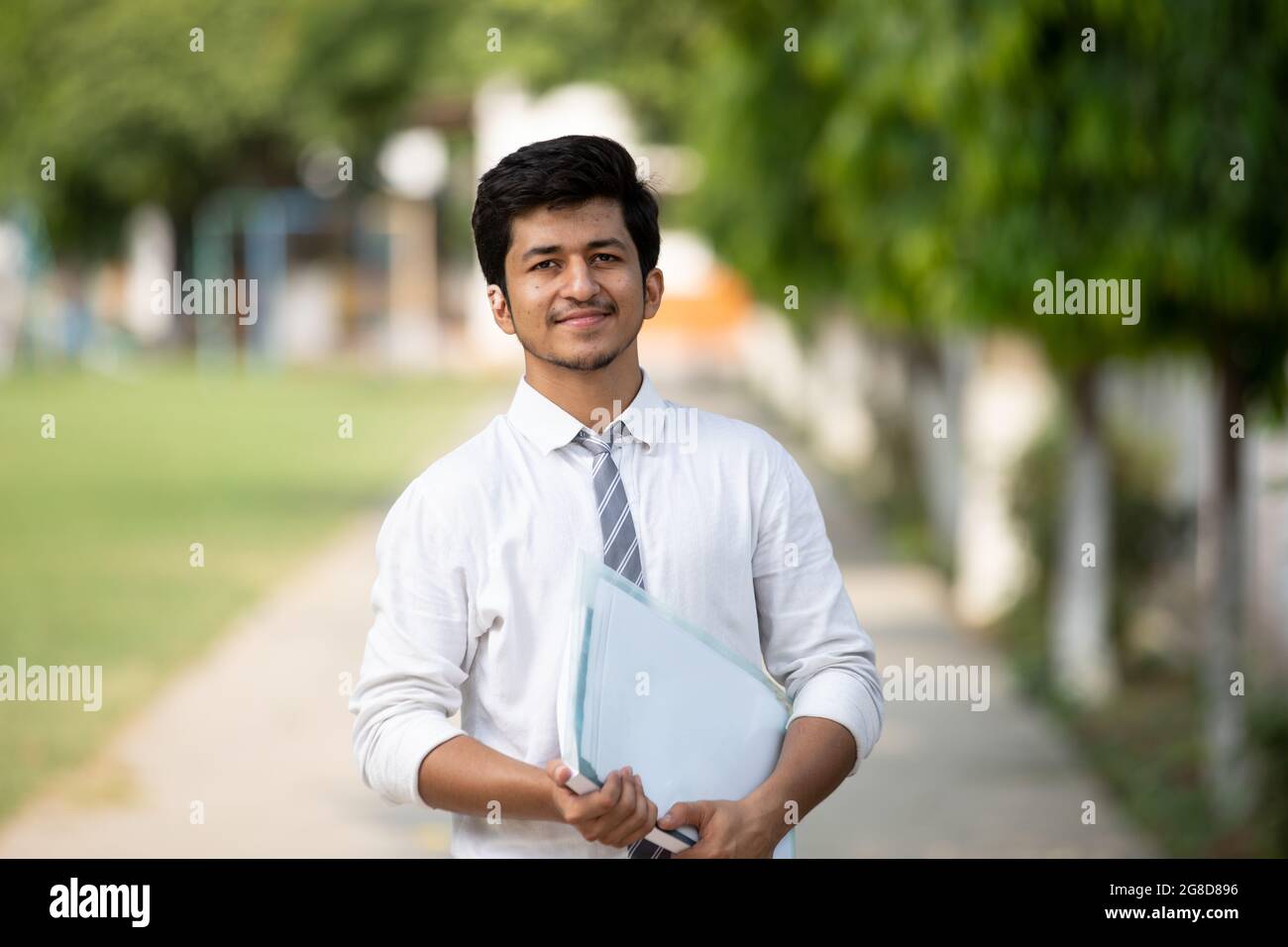 Frontansicht des jungen männlichen Studenten auf dem Campus mit negativem Raum Stockfoto