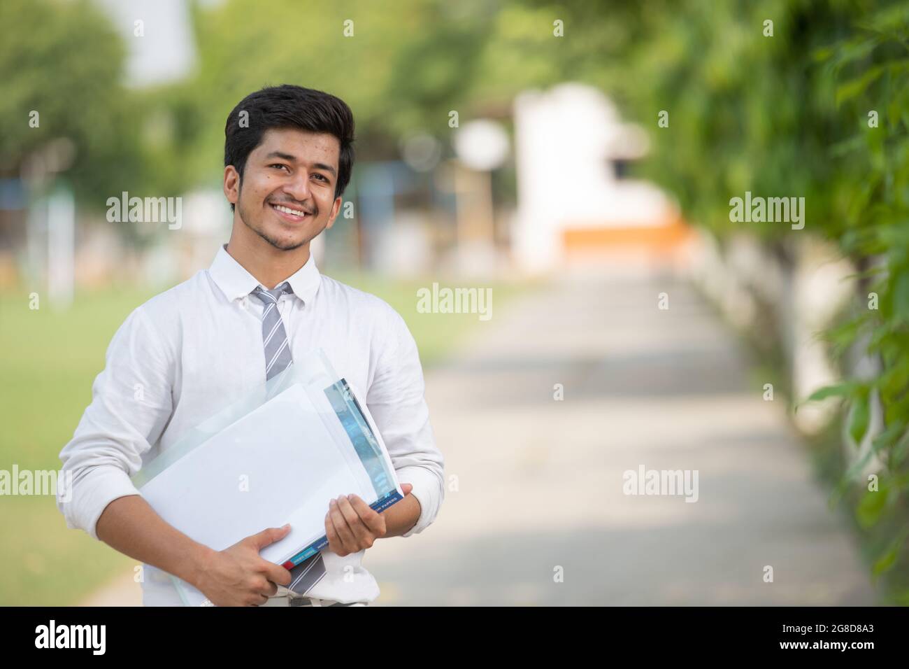 Frontansicht des jungen männlichen Studenten auf dem Campus mit negativem Raum Stockfoto