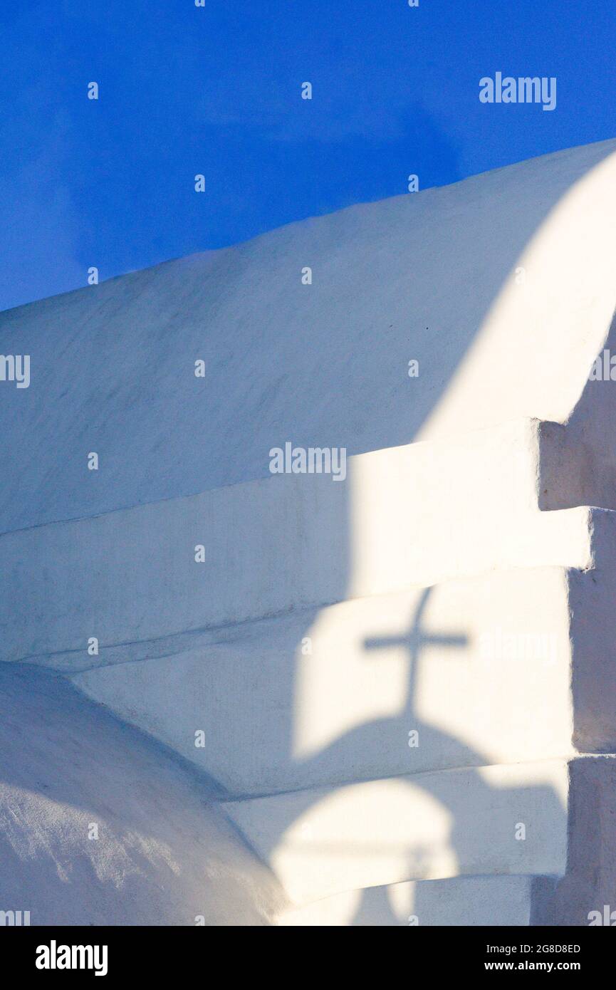 Vertikale Aufnahme, schöne griechische Kapelle. Urlaubsziel der Insel iOS. Schatten werfen sich auf die weiße Wand einer alten Kapelle. Kopierraum, Typografie Stockfoto