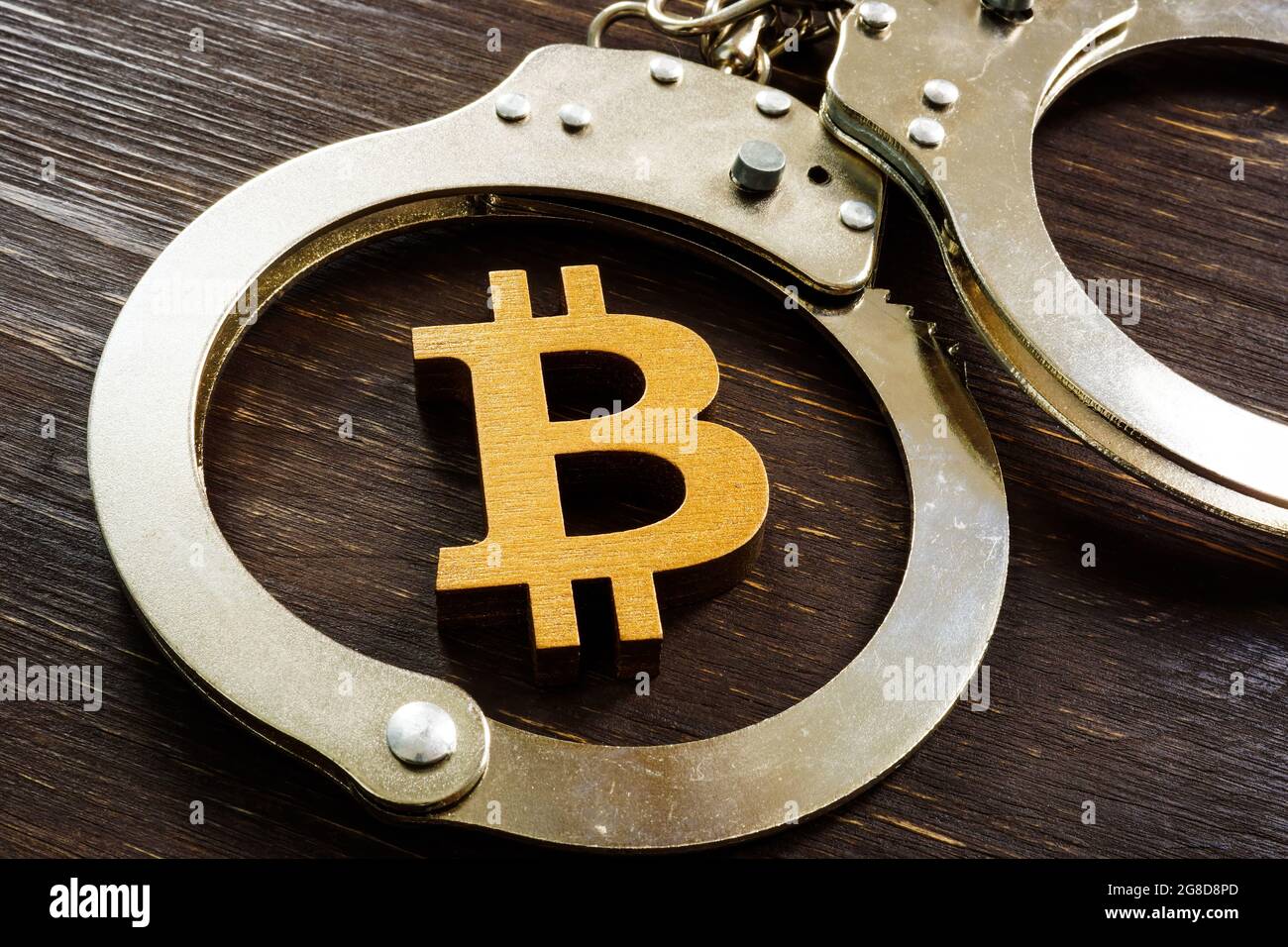 Betrug, Verbot und Regulierung von Kryptowährungen. Bitcoin-Zeichen und Handschellen. Stockfoto