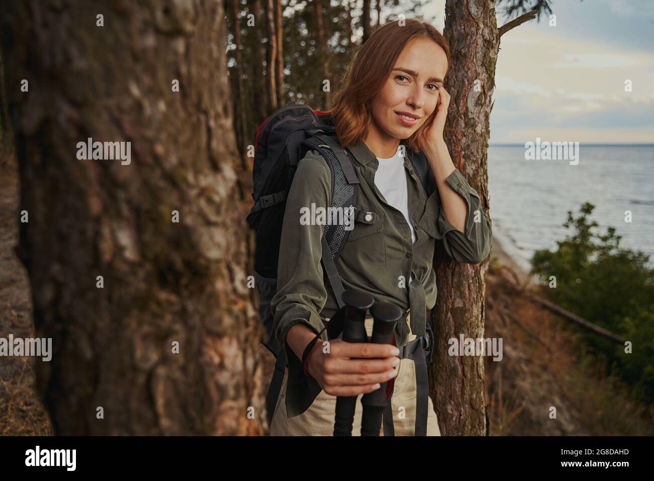 Attraktive Frau, die ihre Haare im Wald fixiert Stockfoto