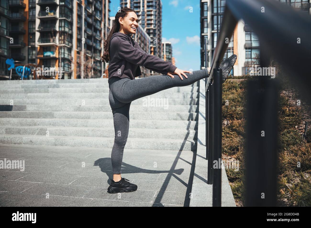 Sportlerin, die im Freien eine Beinstreckungsübung durchführt Stockfoto