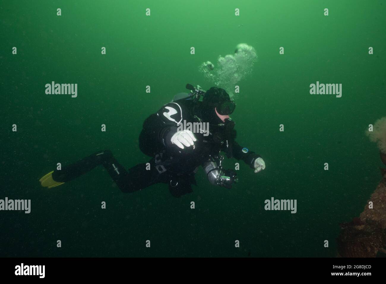 Der technische Taucher trägt einen Trockentauchanzug und sorgt für ein zusätzliches Tauchbecken für tiefe Tauchgänge. Stockfoto