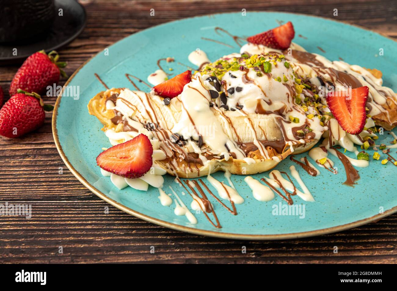 Herzwaffel mit Banane und Erdbeere mit Gummy Candy und Eis darauf. Stockfoto