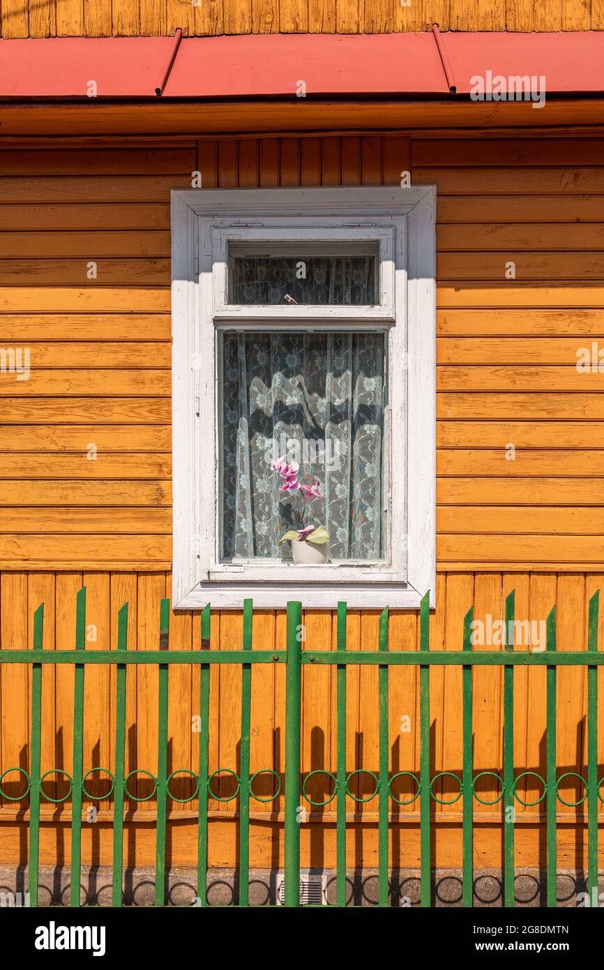 Nahaufnahme eines alten, traditionellen Bauernhauses aus Holz (Wand, Dach und Fenster). Grüner Zaun im Vordergrund. Roztocze, Polen. Stockfoto