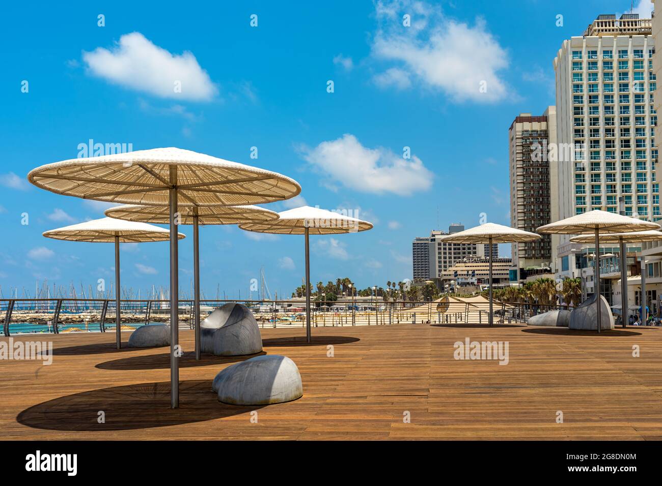 Sonnenschirme und Hochhaushotels an der Promenade entlang des Mittelmeers in Tel Aviv, Israel. Stockfoto