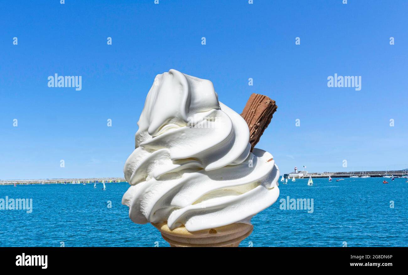 Ein Eis aus dem Jahr 99, das vor blauem Himmel und klarem, blauem Meer serviert wird. Stockfoto