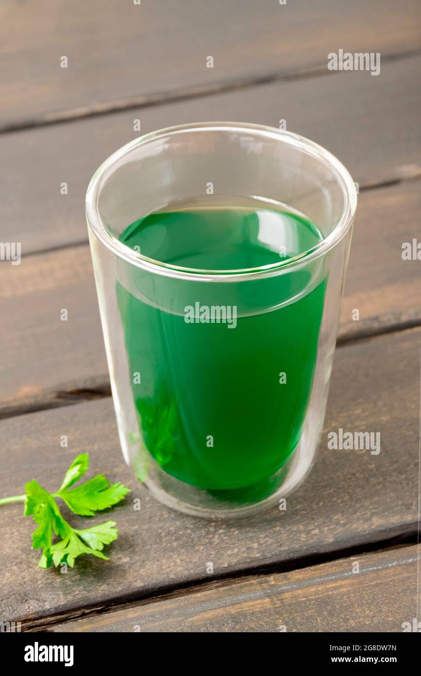 Tasse Chlorophyllwasser auf hölzernem Hintergrund Stockfoto