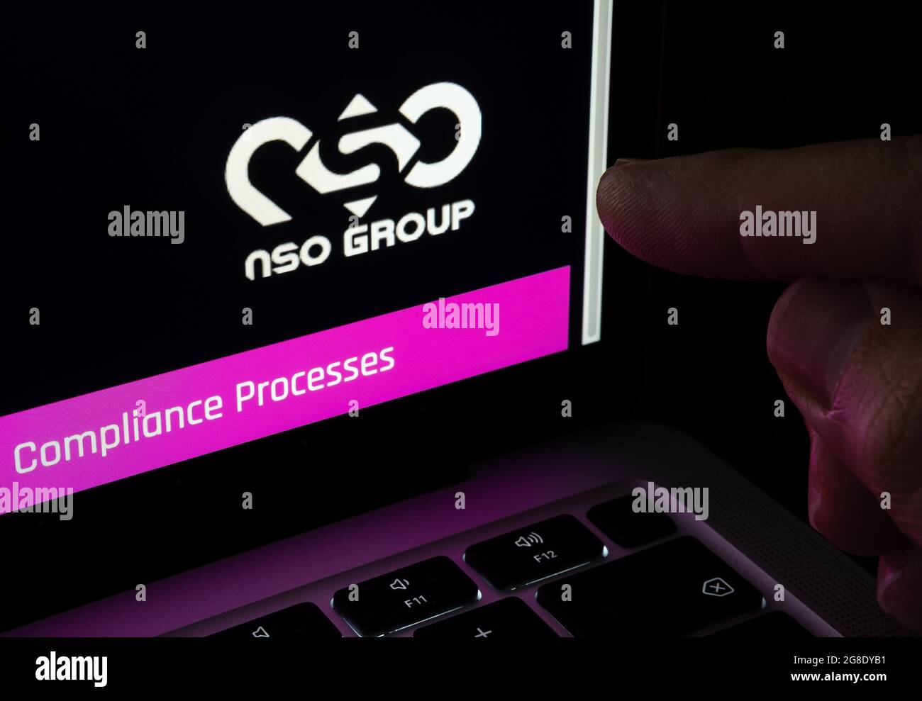Der Finger zeigt auf das verschwommene Logo der NSO Group auf der Unternehmenswebsite, die auf einem Laptop zu sehen ist. Israelisches Unternehmen, das für seine Spyware-Software bekannt ist. Selektiver Fokus. Stafford Stockfoto