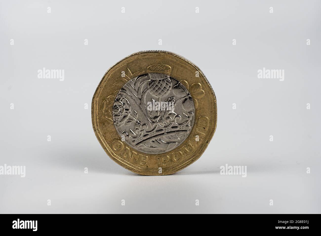 Britische 1-Pfund-Münze Makro-Foto. Münze mit den Zeichen der Zirkulation, abgenutzter Zustand. Isoliert auf Weiß. Stockfoto