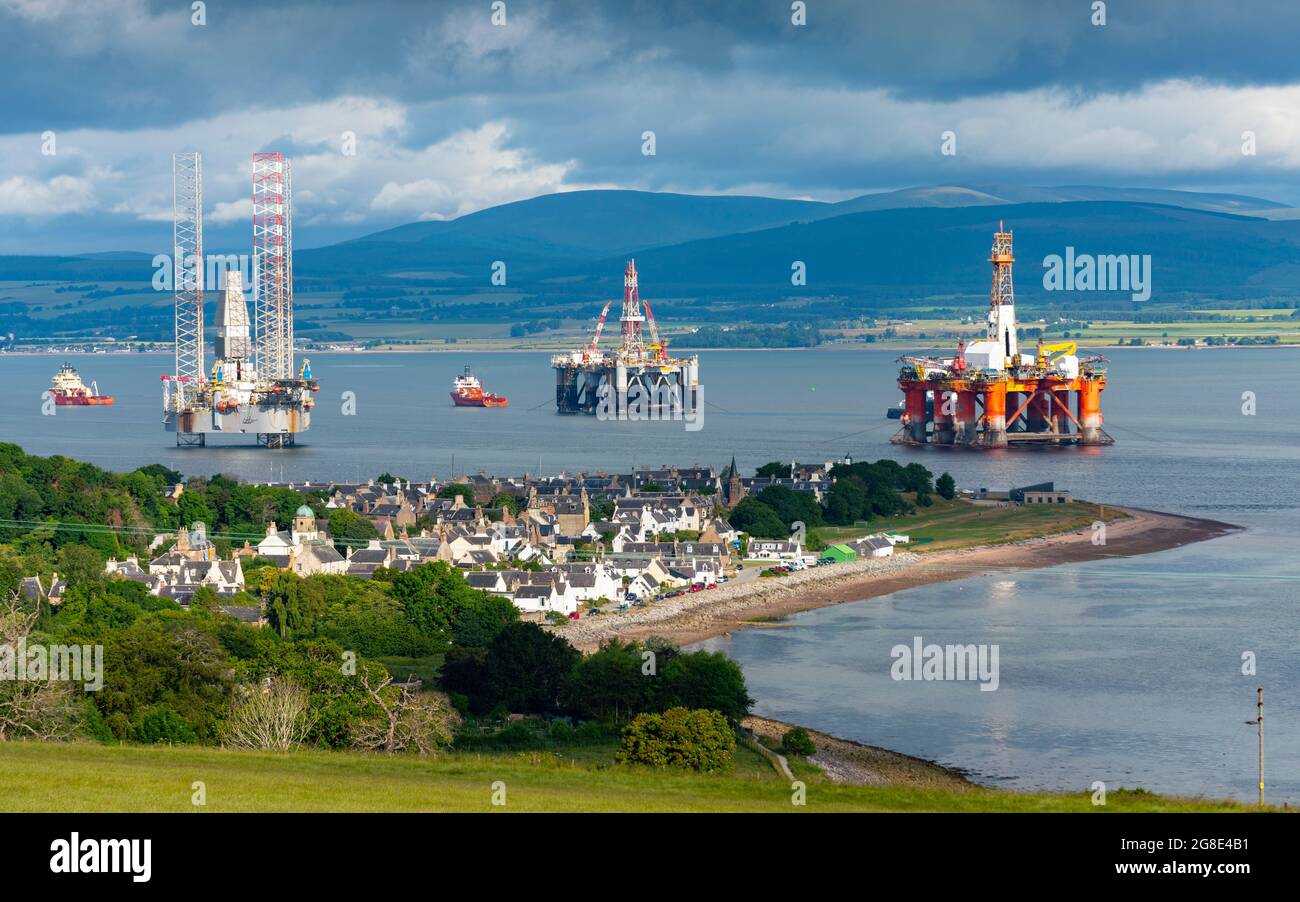 Blick auf das Dorf Cromarty und alte und gasbetriebene Plattformen und Bohrinseln, die in Nigg Bay auf der Black Isle auf Cromarty Firth, Ross und Cromarty, Schottland, festgemacht sind, Stockfoto