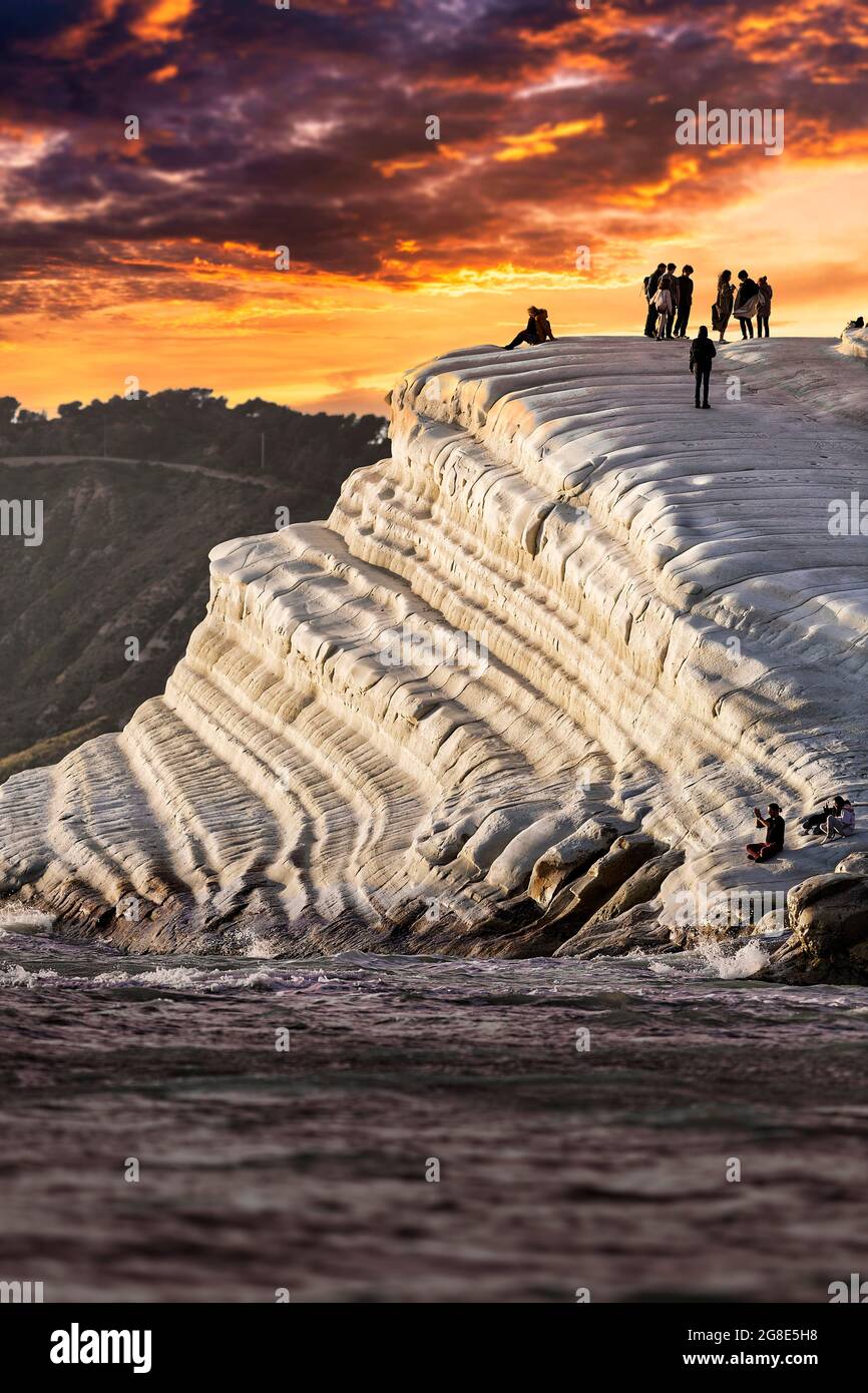 Sonnenuntergang an der felsigen Küste, Kreidefelsen Scala dei Turchi, Besucher auf türkischen Treppen, Realmonte, Sizilien, Italien Stockfoto