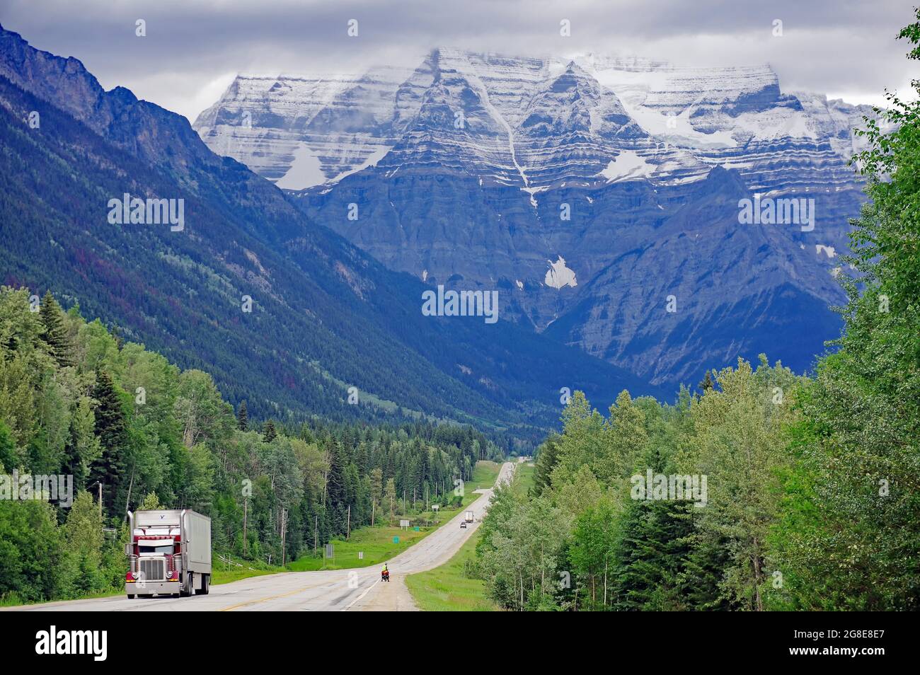 Autobahn mit LKW und Radfahrer, schneebedeckte Berge im Hintergrund, Trans Canada Highway, Mount Robson, British Columbia, Kanada Stockfoto